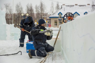 Çalışan bir chainsaw buz plaka bir buz şehirde testereleri