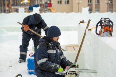 Çalışan bir chainsaw buz plaka bir buz şehirde testereleri