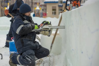 Çalışan bir chainsaw buz plaka bir buz şehirde testereleri