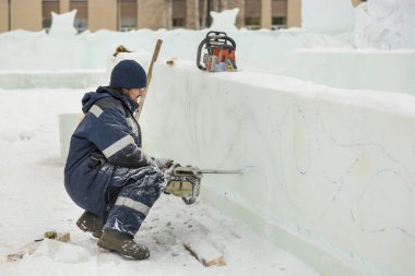 Çalışan bir chainsaw buz plaka bir buz şehirde testereleri