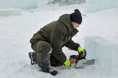 Çalışan bir chainsaw buz plaka bir buz şehirde testereleri