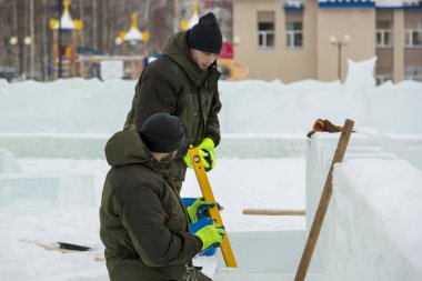 İşçiler birleştiricileri inşaat alanı üzerinde buz blok buz şehrin işaretlemek