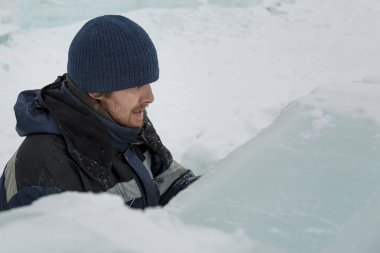 Heykeltıraş, buzdan bir heykeli Noel için keskiyle kesiyor.