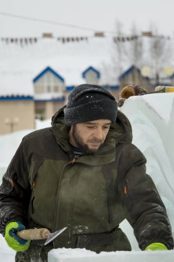 Heykeltıraş buz kalıbından bir buz kalıbını kesiyor.