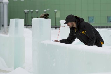 Sanatçı, buzun üzerinde geleceğin buz figürünün hatlarını çizer.