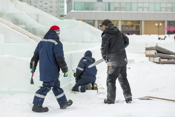 Workers build an ice town for the Christmas holidays