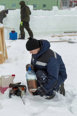 İşçi el ile tüp yağdan chainsaw Redüktör dökülen.