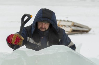 Buz kasabası kurmakla meşgul bir işçinin portresi.