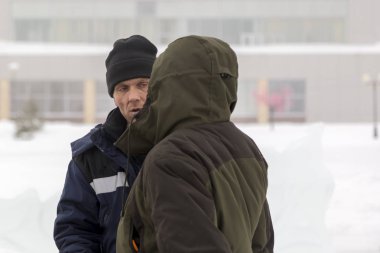 Bir konuşma için buz şehrin inşaat sahasında işçiler