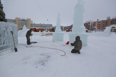 Elektrikçiler Buz figürleri aydınlatmak için bir güç kablosunu bağlama.