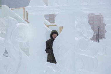 Heykeltıraş, buzdan bir heykeli Noel için keskiyle kesiyor.