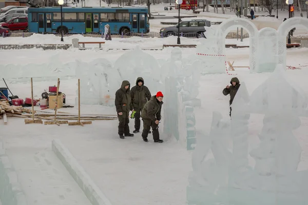 Workers on the construction of an ice camp discuss a plan