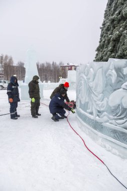 Elektrikçiler Buz figürleri aydınlatmak için bir güç kablosunu bağlama.
