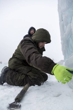 Elektrikçiler Buz figürleri aydınlatmak için bir güç kablosunu bağlama.