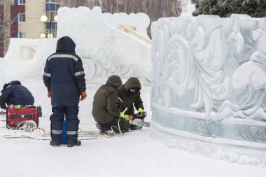 Elektrikçiler Buz figürleri aydınlatmak için bir güç kablosunu bağlama.
