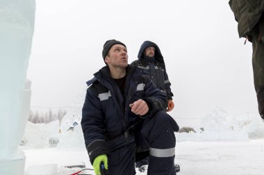 Elektrikçiler Buz figürleri aydınlatmak için bir güç kablosunu bağlama.