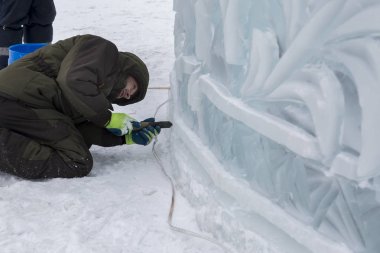 Elektrikçi Buz figürleri aydınlatmak için güç kablosunu bağlar.