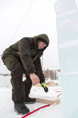 Elektrikçi Buz figürleri aydınlatmak için güç kablosunu bağlar.
