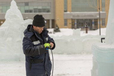 Elektrikçi Buz figürleri aydınlatmak için güç kablosunu bağlar.