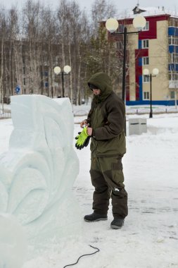 Bir işçi bir buz şehir düzenlenmesine meşgul bir kukuleta ile yeşil ceketli portresi