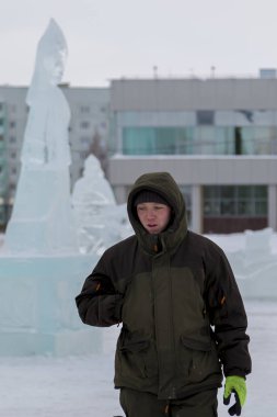 Bir işçi bir buz şehir düzenlenmesine meşgul bir kukuleta ile yeşil ceketli portresi