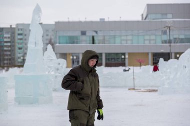 Bir işçi bir buz şehir düzenlenmesine meşgul bir kukuleta ile yeşil ceketli portresi