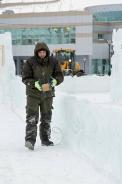 Elektrikçi Buz figürleri aydınlatmak için güç kablosunu bağlar.