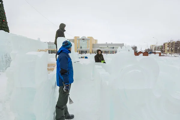 Workers on the construction of an ice camp discuss a plan