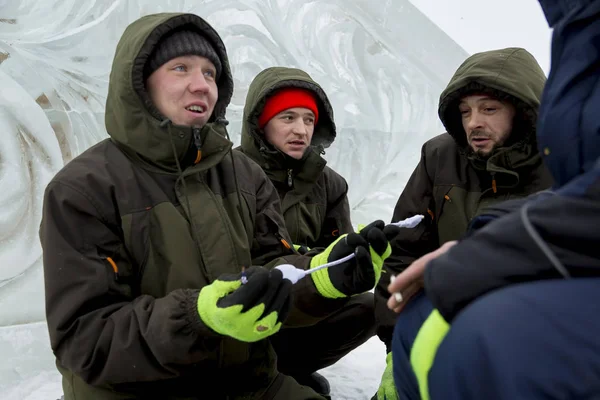 Workers on the construction of an ice camp discuss a plan