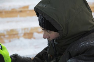 Heykeltıraş, buzdan bir heykeli Noel için keskiyle kesiyor.
