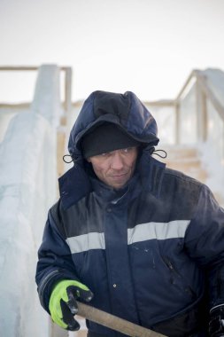 Buz kasabası kurmakla meşgul bir işçinin portresi.