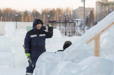 Buz kasabası kurmakla meşgul bir işçinin portresi.