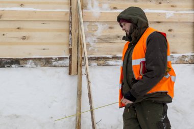Onun elinde bir mezura ile derleme sitede çalışma yükleyici gider