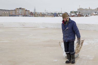 Bir mavi ceket ve kafasında kahverengi örgü şapka işçi