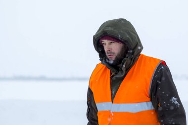 Yeşil bir ceket kukuIeta ve yansıtıcı yelek işyerinde işçi