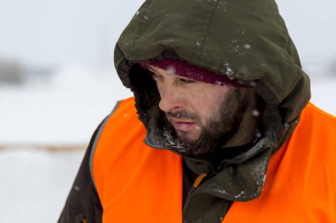 Yeşil bir ceket kukuIeta ve yansıtıcı yelek işyerinde işçi