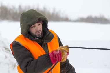 Yeşil bir ceket kukuIeta ve yansıtıcı yelek işyerinde işçi