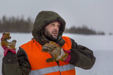 Yeşil bir ceket kukuIeta ve yansıtıcı yelek işyerinde işçi