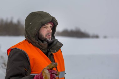 Yeşil bir ceket kukuIeta ve yansıtıcı yelek işyerinde işçi