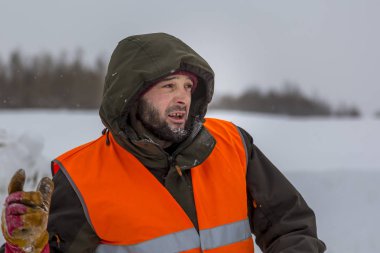 Yeşil bir ceket kukuIeta ve yansıtıcı yelek işyerinde işçi