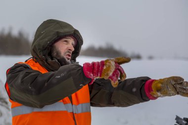 Yeşil bir ceket kukuIeta ve yansıtıcı yelek işyerinde işçi