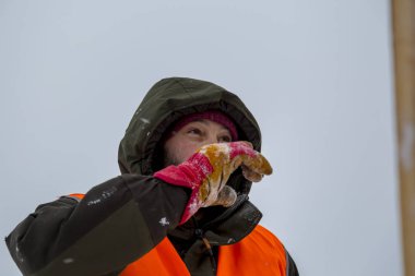 Yeşil bir ceket kukuIeta ve yansıtıcı yelek işyerinde işçi