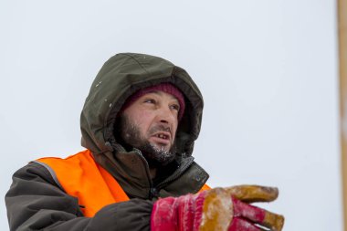 Yeşil bir ceket kukuIeta ve yansıtıcı yelek işyerinde işçi