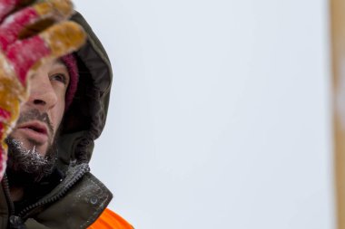 Yeşil bir ceket kukuIeta ve yansıtıcı yelek işyerinde işçi