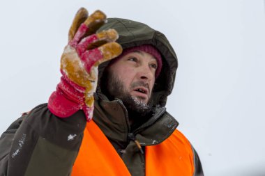 Yeşil bir ceket kukuIeta ve yansıtıcı yelek işyerinde işçi