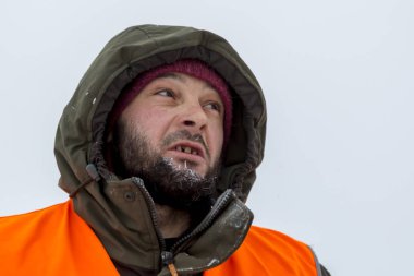 Yeşil bir ceket kukuIeta ve yansıtıcı yelek işyerinde işçi