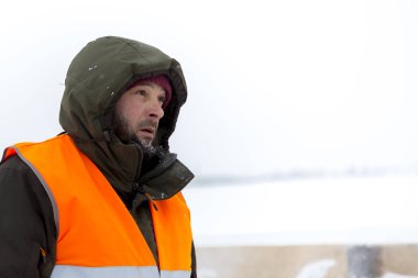 Yeşil bir ceket kukuIeta ve yansıtıcı yelek işyerinde işçi