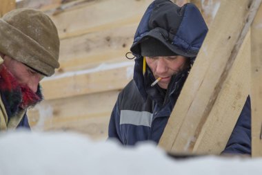 Mavi bir ceket ve kafasında bir kukuleta ile bir işçi ve bir sigara ağzında portre