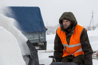İşçi kar kar makinesi kullanarak tipide kaldırır.
