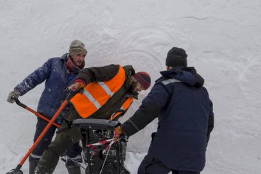 İşçiler kar tipide bir kar temizleme aracı kullanarak kaldırın.